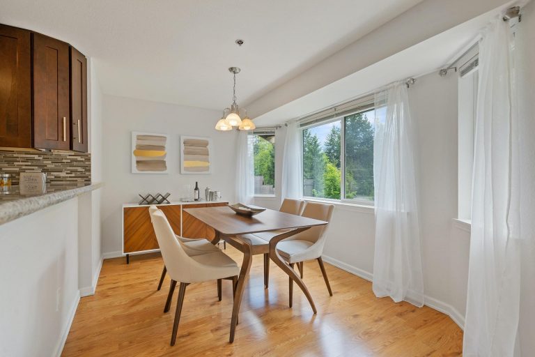 Dining room table in a room with large windows and wood floors