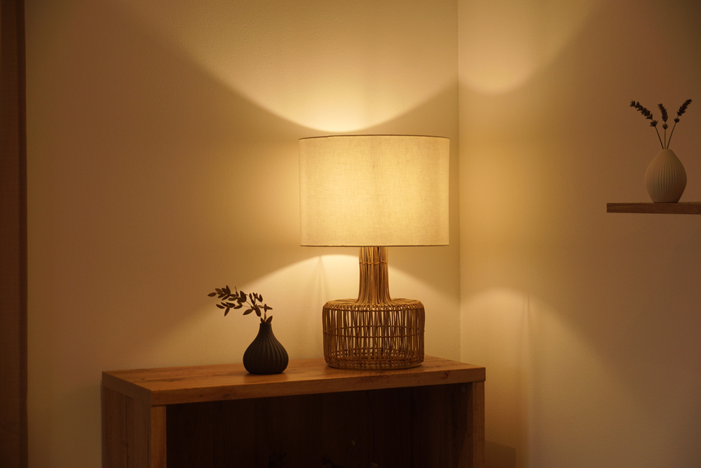 View of a cozy decorative corner with a table lamp spending warm light