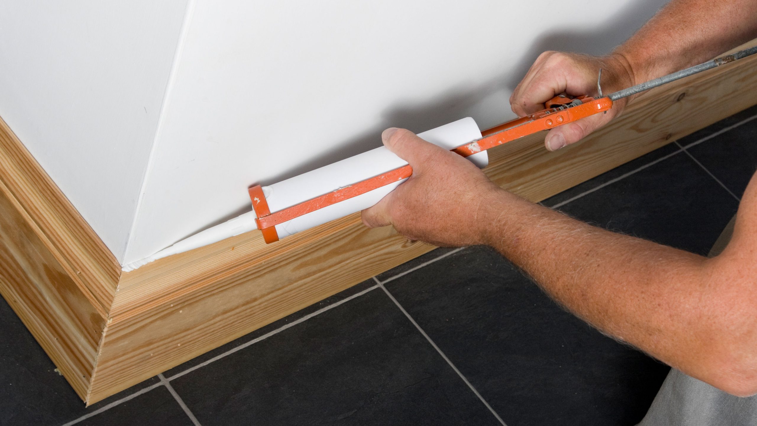 Premium Photo | View on male hands fitting skirting board