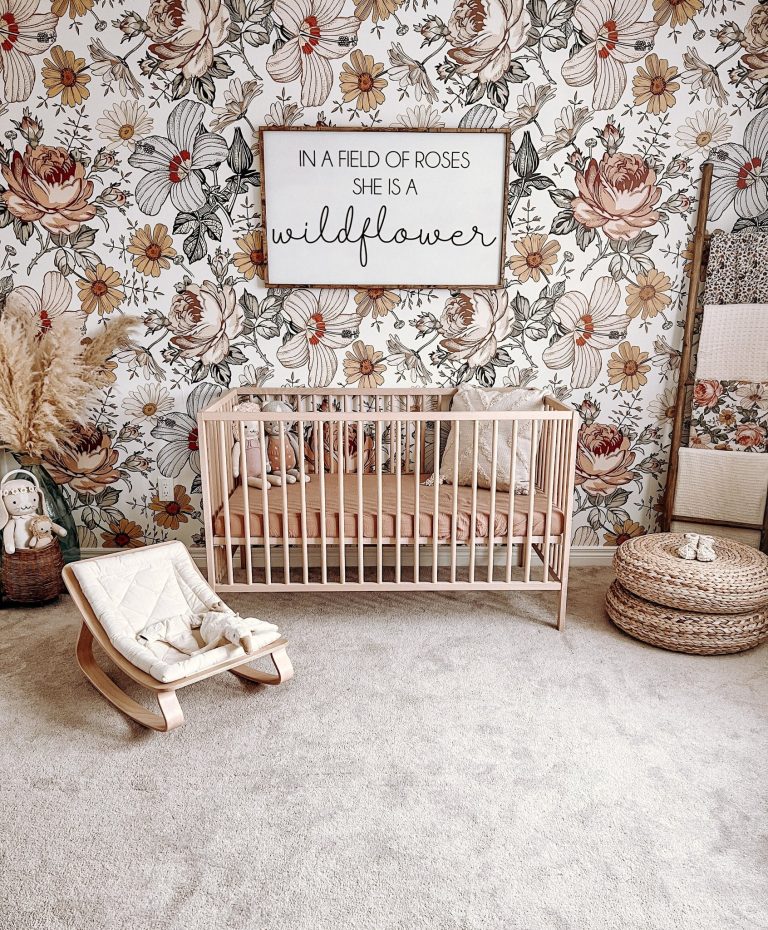 A crib in a room with floral wallpaper Description automatically generated