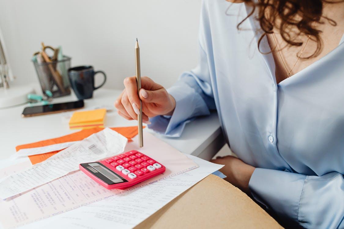 woman typing on calculator computing bills

A Woman Computing Bills while Holding a Pencil Stock Photo